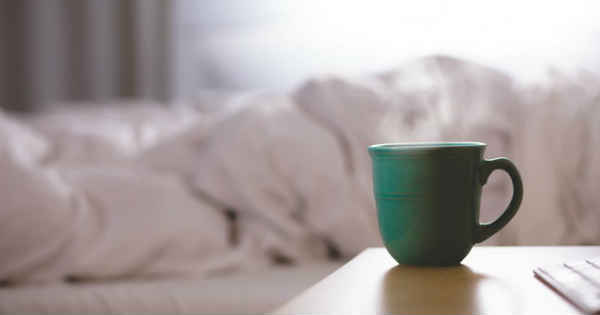 warm coffe in a cup in front of bed